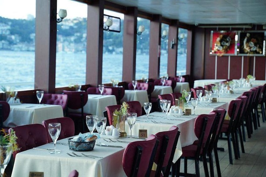 A restaurant with tables set for dining, overlooking a body of water. 2