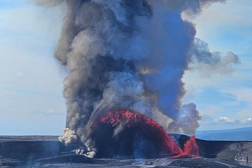 Una erupción volcánica con lava fluyendo y denso humo elevándose. 3