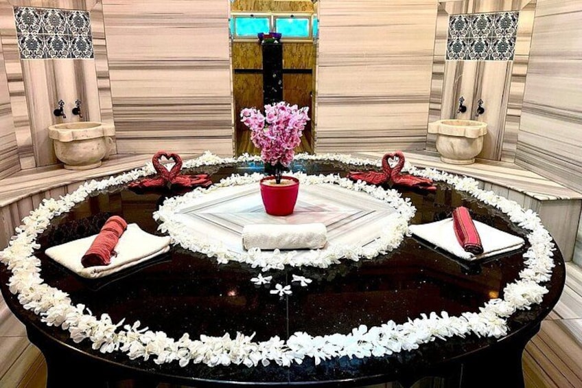 A round table with a black marble top, surrounded by white flowers and red heart-shaped decorations. 2