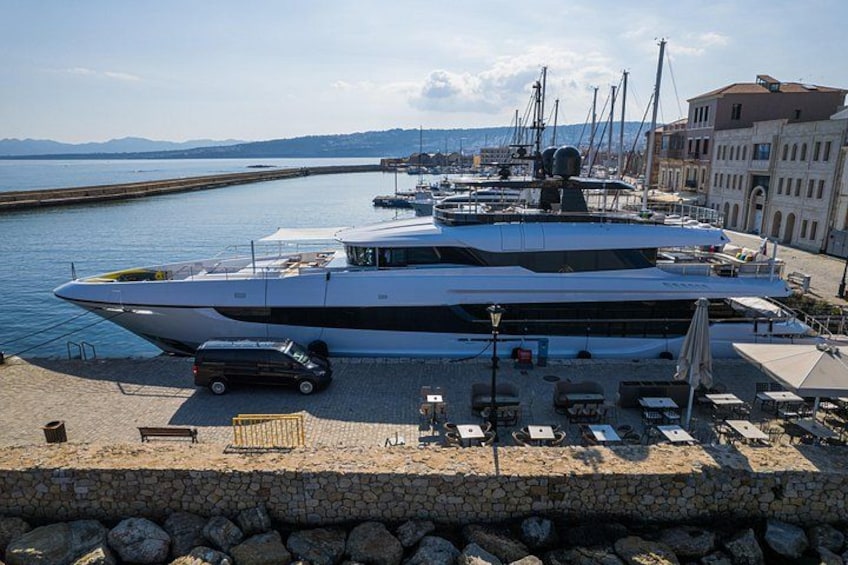 Un grand yacht était amarré dans une marina, avec un mur de pierre et des chaises longues en premier plan. 2