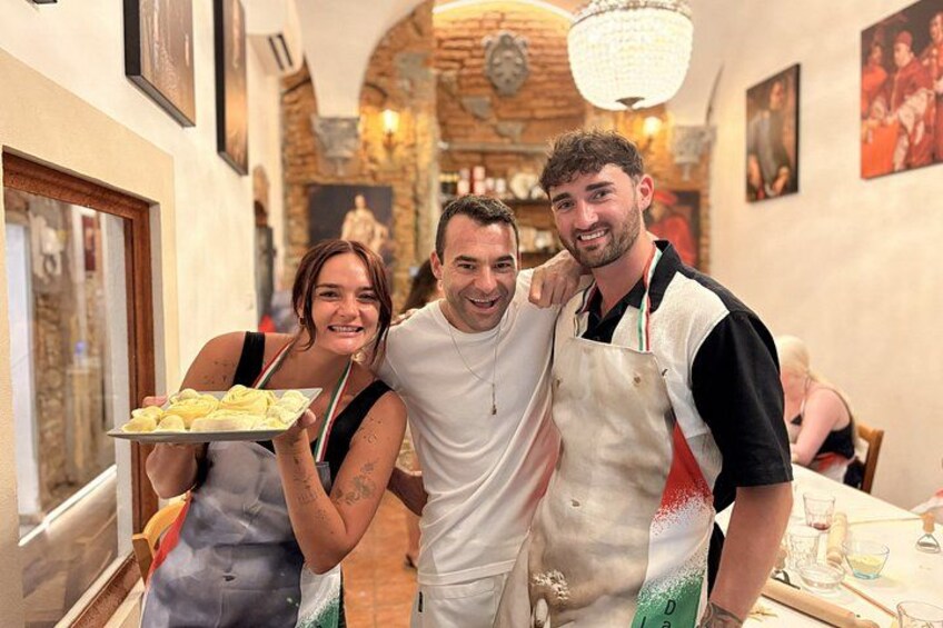 Drei Personen in einem Restaurant mit Backsteinwand und Kronleuchter. 1