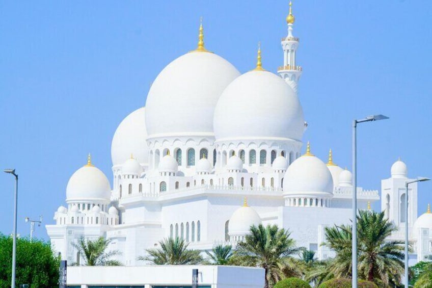 A large white mosque with multiple domes and golden spires. 5
