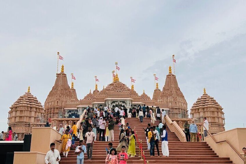 A temple with multiple spires and a crowd of people ascending the steps. 3
