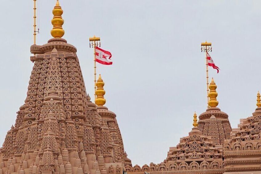A temple with intricate carvings and multiple spires, each topped with a golden finial and a flag. 4