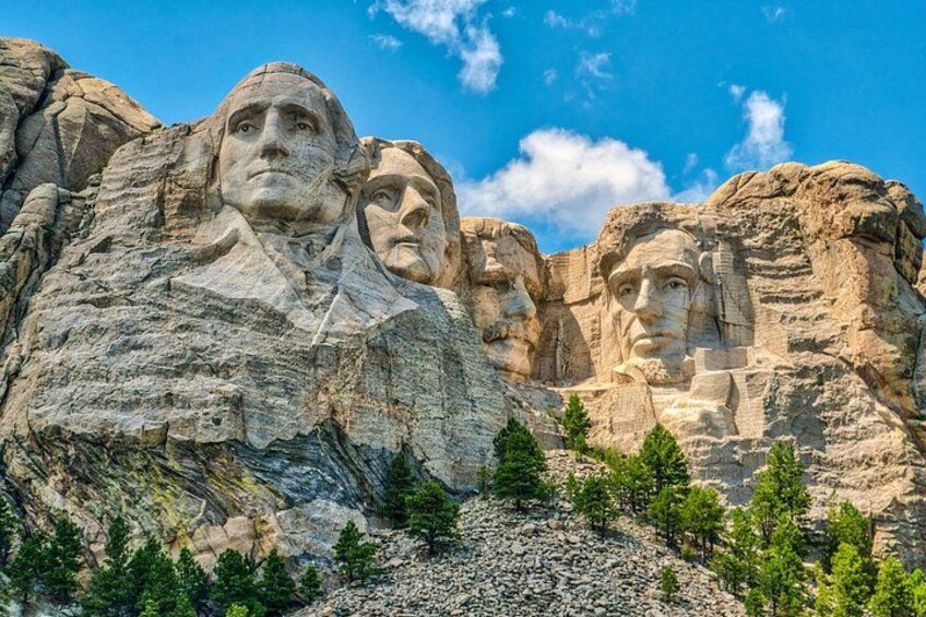Mount Rushmore with four faces carved into the rock. 1