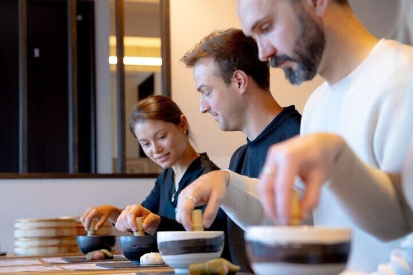 Drie mensen bereiden eten met kommen en stokjes. 1