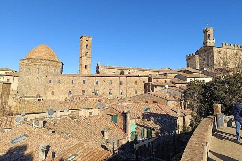 A historic cityscape with a prominent tower, a dome, and a castle-like structure. 5