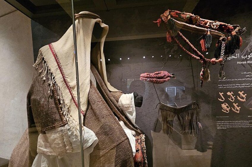 A mannequin dressed in traditional attire with a shawl and a headpiece. 1