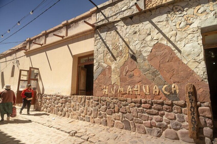 A stone building with 'AHUACACA' carved on the wall. 2