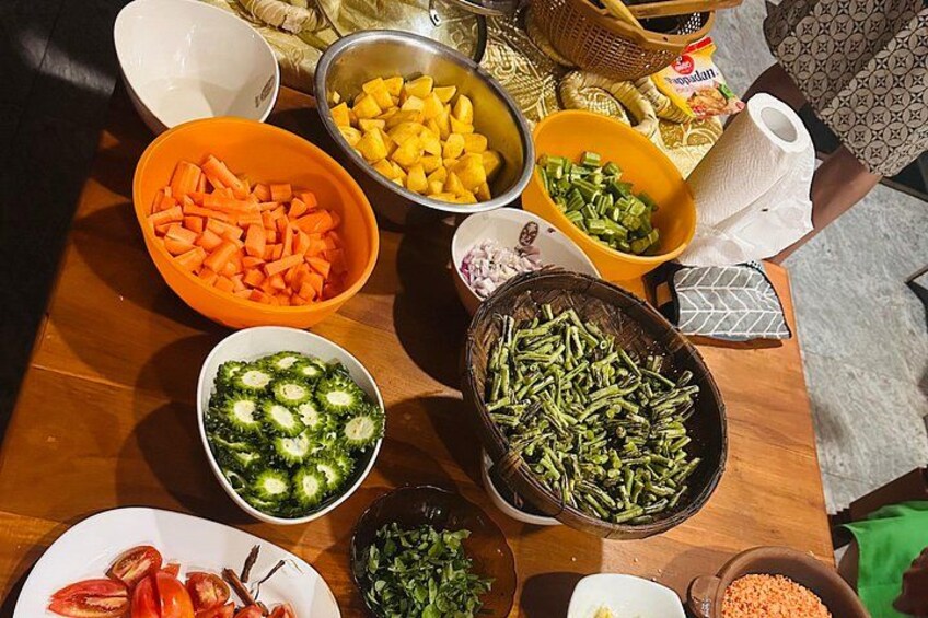 Une table garnie de divers légumes et ingrédients, notamment des carottes, des brocolis, des haricots verts et des tomates. 3