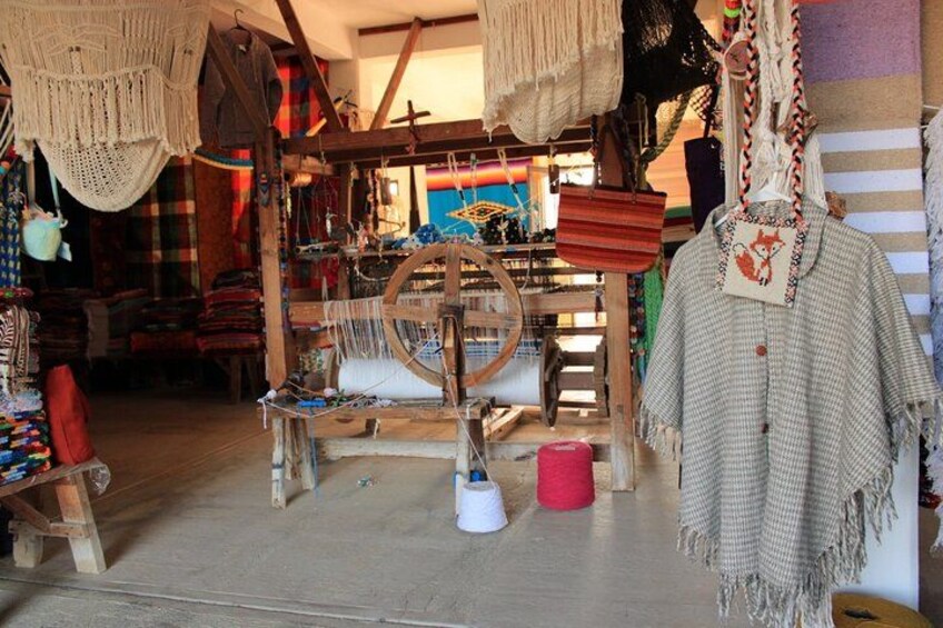 A craft workshop with weaving looms, colorful textiles, and handmade items. 2