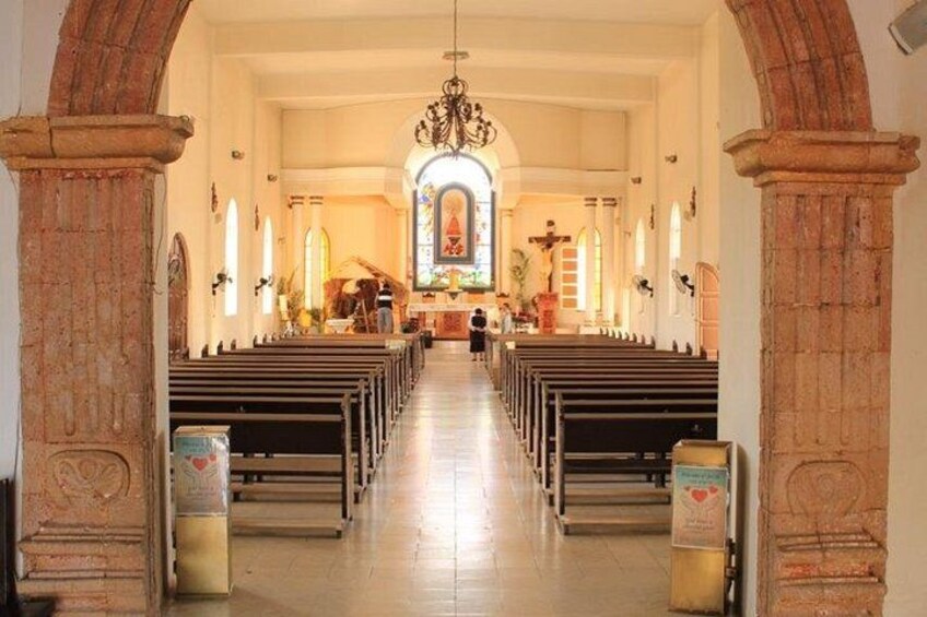 L’intérieur d’une église avec des bancs, un vitrail et une croix. 2