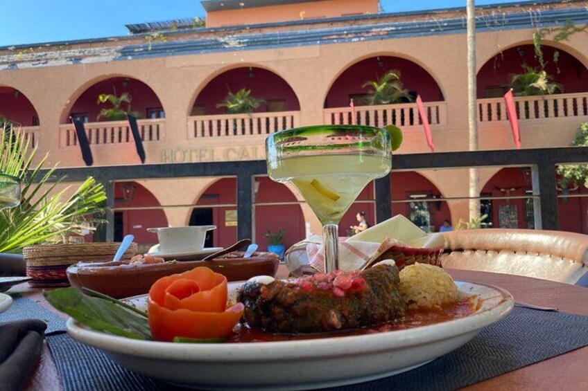 A meal with a margarita, a bowl of soup, and a plate of food with a decorative flower. 3
