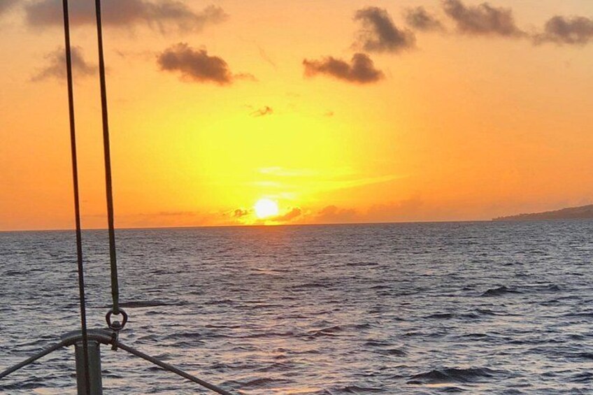 A sunset over the ocean with a boat in the foreground. 4