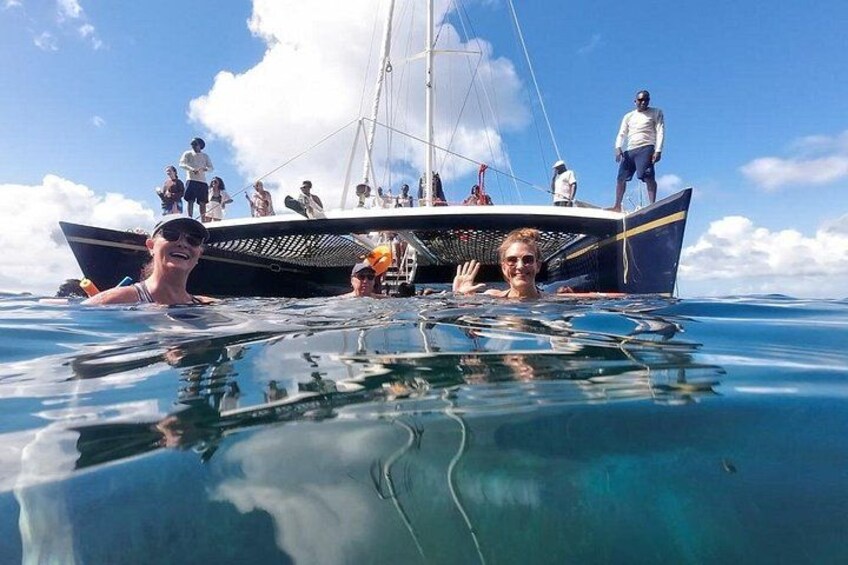 A sailboat with people on board and some standing on the deck. 1
