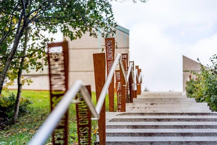 A staircase with metal railings and wooden posts, leading up to a building. 2