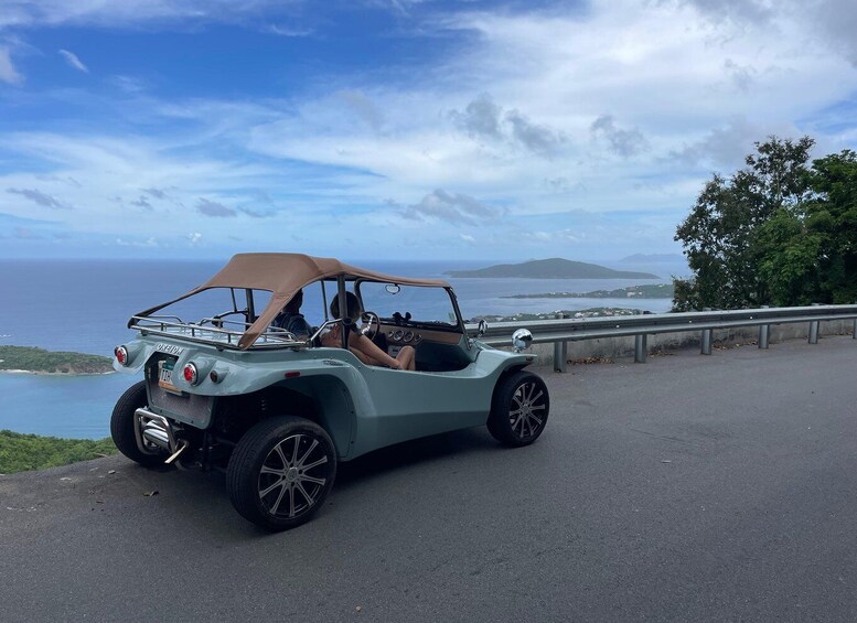 A light green vintage car parked on a road with a coastal view. 3