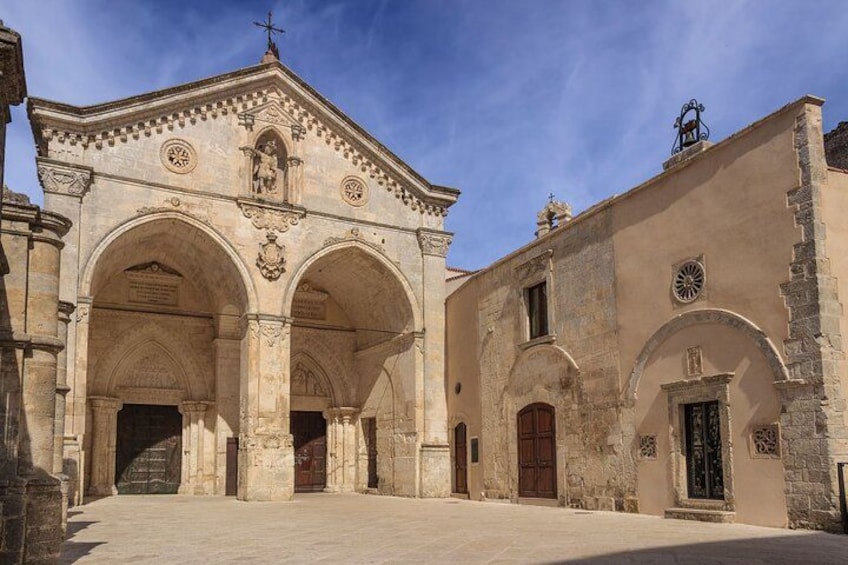 A historic building with arches and a cross on top. 2