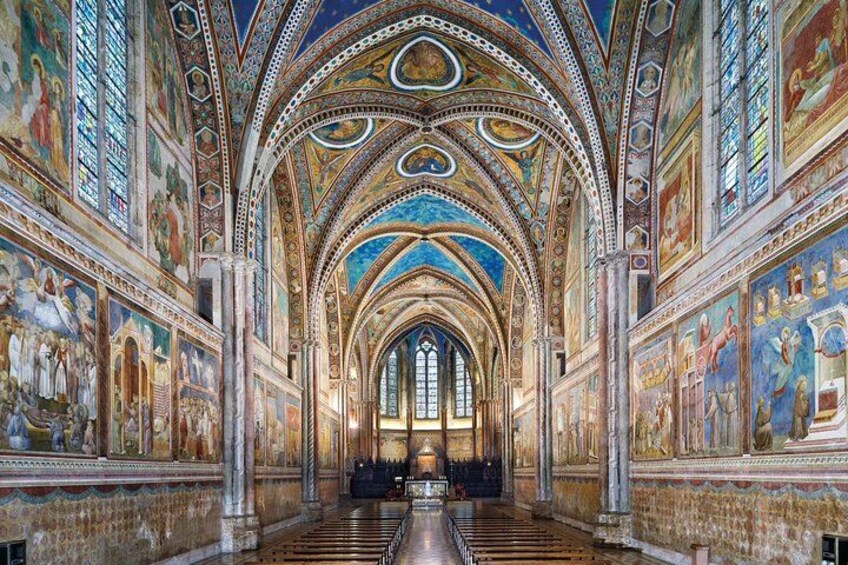 L'interno maestoso di una cattedrale, con soffitti a volta alti, affreschi dettagliati e una lunga navata. 2