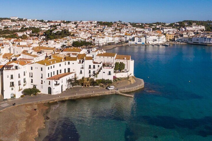 A coastal town with white buildings and a clear blue sea. 2