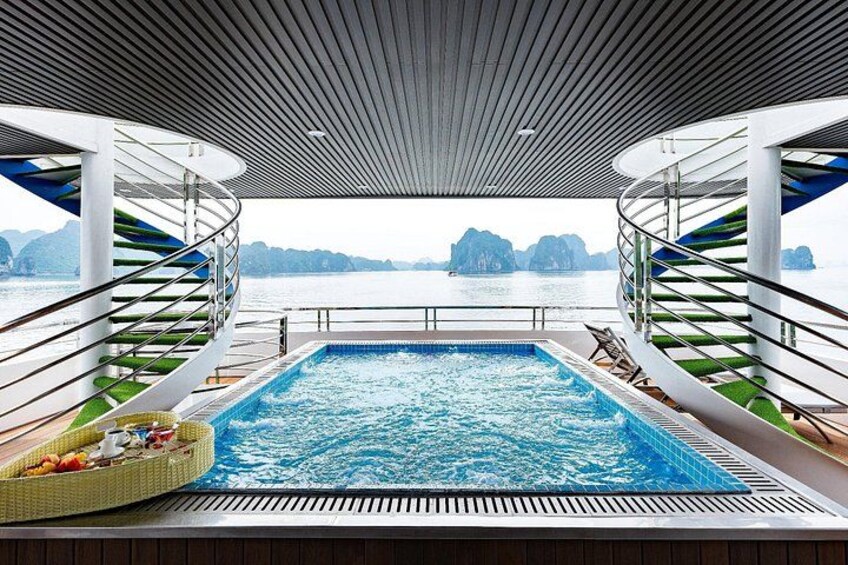 Una piscina con vistas al mar y a las islas, rodeada por una terraza con sillas y una escalera. 4
