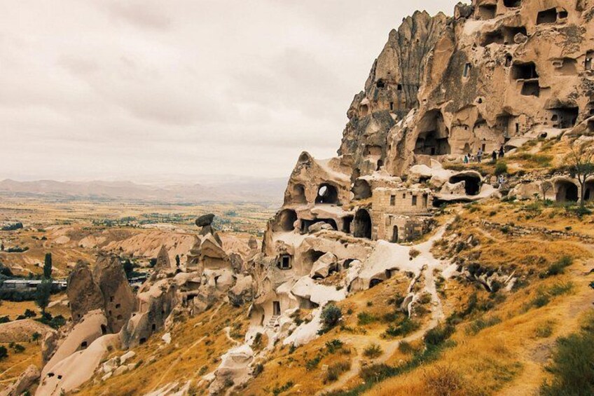 A rocky landscape with ancient rock-cut dwellings. 1