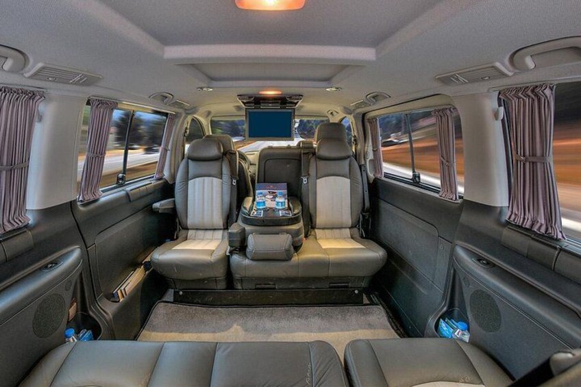 A luxurious interior with leather seats, a central console, and curtains. 2