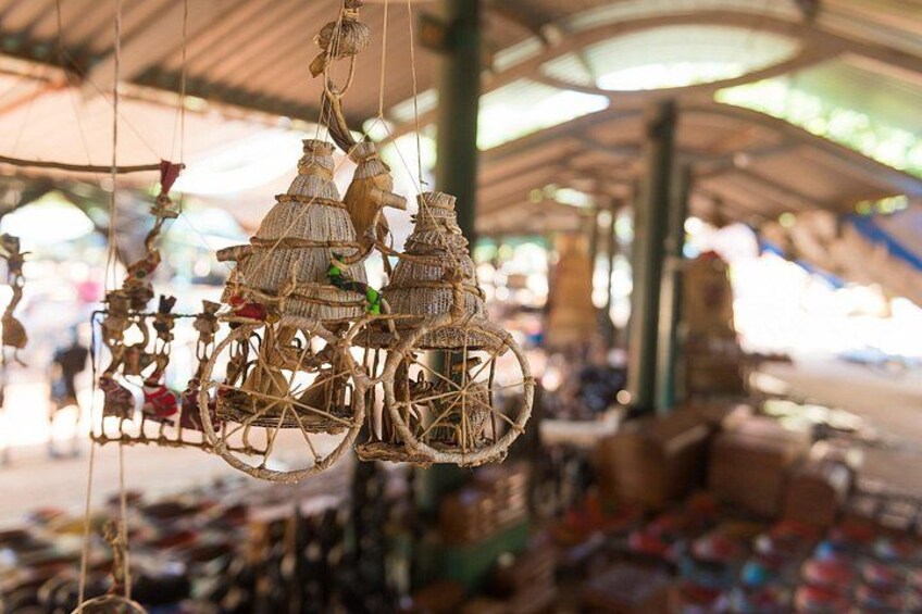 Un puesto de mercado con jaulas de pájaros colgantes y diversos artículos a la venta. 2