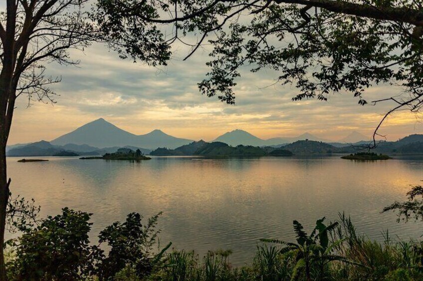 A calm lake with mountains in the background and trees in the foreground. 1