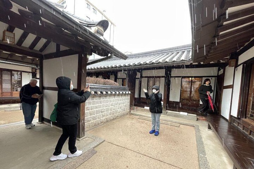 A traditional Japanese building with a tiled roof, a wooden structure, and a stone wall. 4