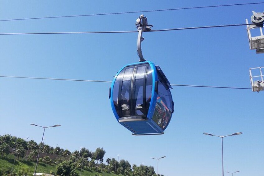 A blue cable car suspended by cables against a clear sky. 1