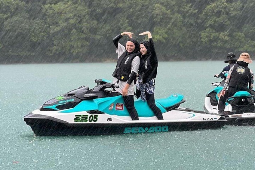 Deux personnes sur un jet ski, sur une étendue d’eau, avec des arbres en arrière-plan. 2