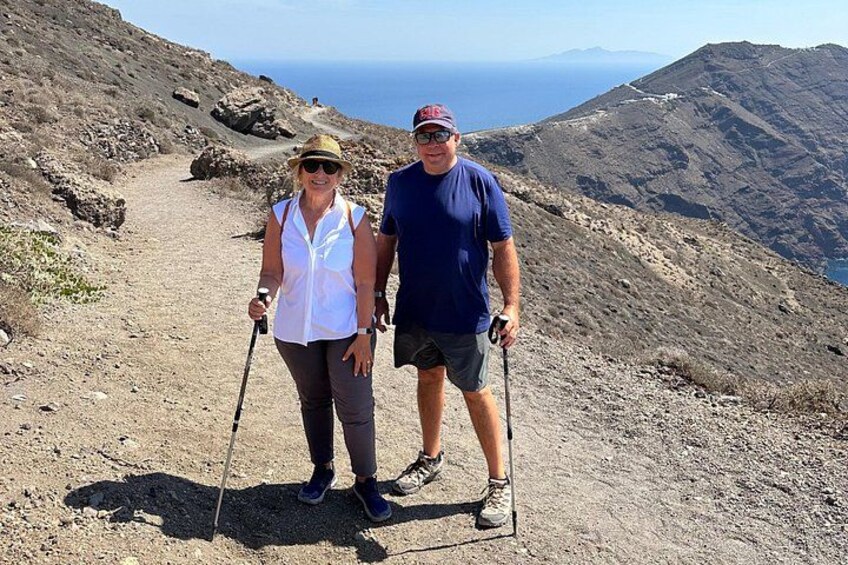 Deux personnes font de la randonnée sur un sentier rocailleux, avec un paysage montagneux en arrière-plan. 5