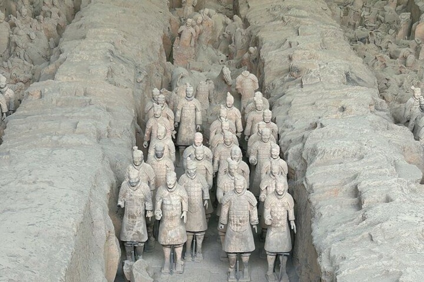 A large group of terracotta soldiers lined up in a formation. 4