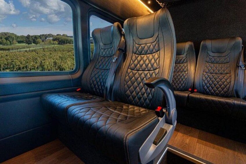 A vehicle interior with leather seats and a wooden floor. 3