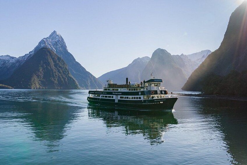 A boat on a calm lake with mountains in the background. 2