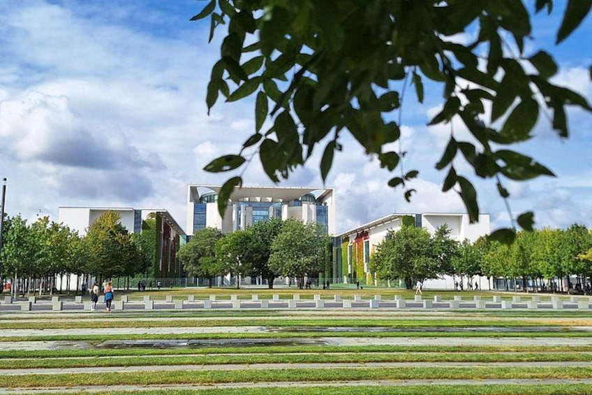 Un complejo moderno de edificios con una estructura central de vidrio, rodeado de árboles y zonas verdes abiertas. 5