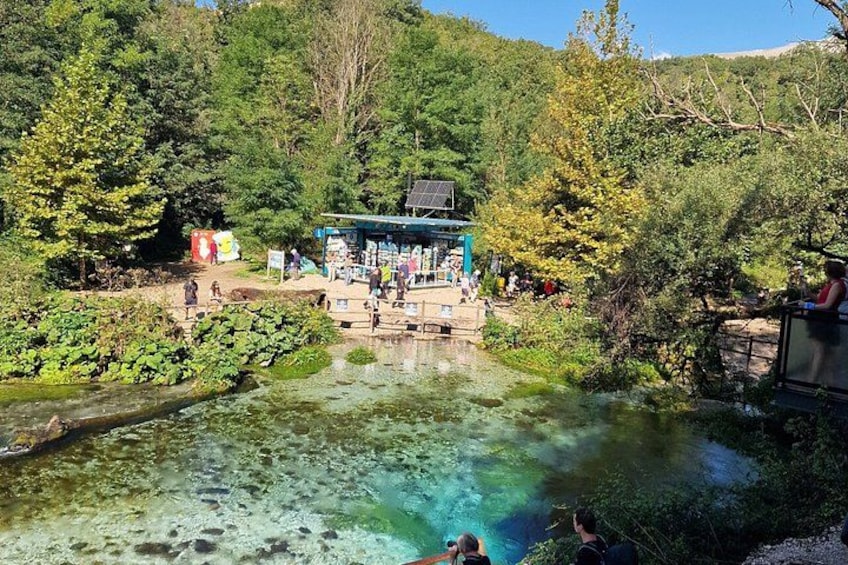 Ein natürlicher Thermalquell, umgeben von üppiger Vegetation, einem kleinen Pavillon und einem klaren Wasserbecken. 3
