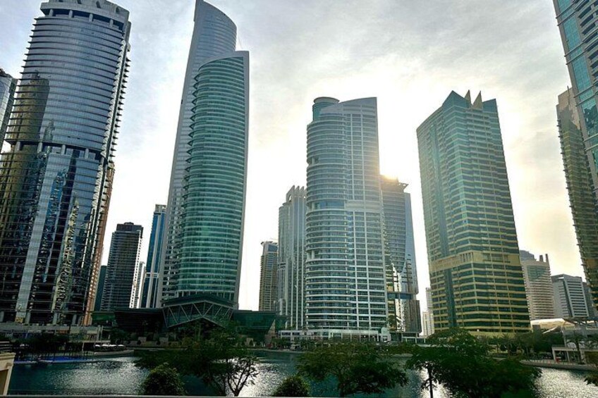 A cityscape with modern skyscrapers, a body of water, and a bridge. 3