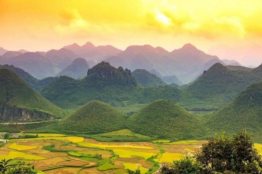 Terraced rice fields, rolling hills, and a mountain range in the background. 2