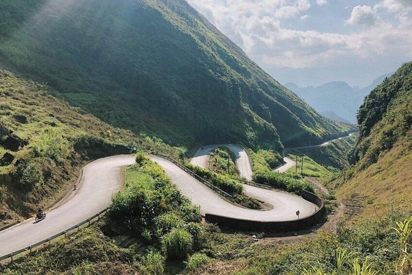 A winding mountain road with a motorcycle. 2