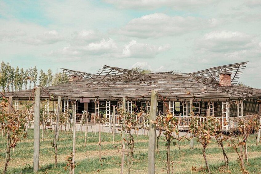 A dilapidated building with a collapsed roof, surrounded by a fence and sparse vegetation. 2
