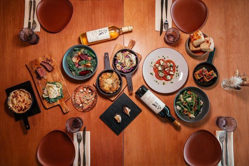 A wooden table with various dishes, bottles, and cutlery. 3