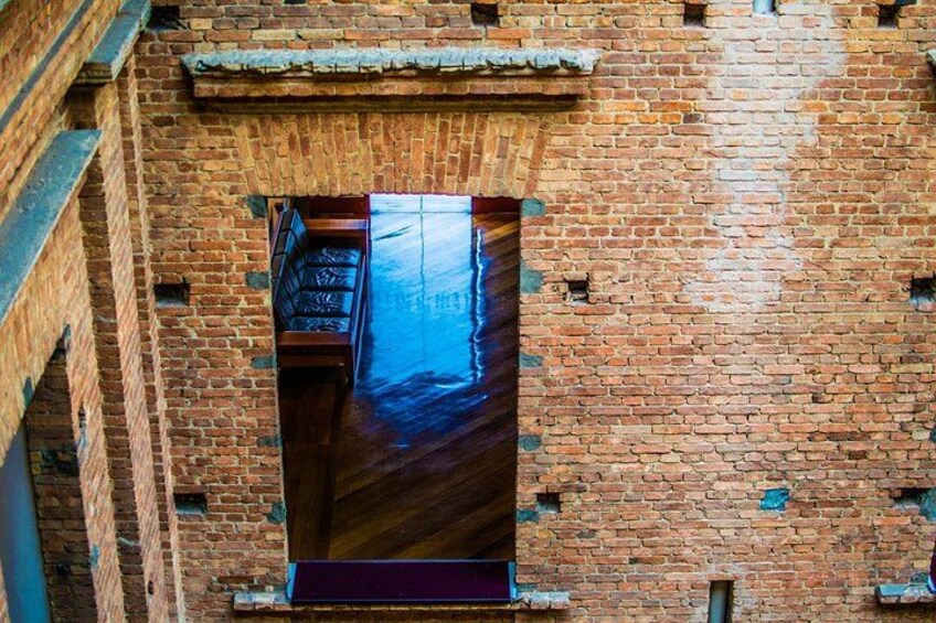 A brick wall with a wooden door and a large window. 3