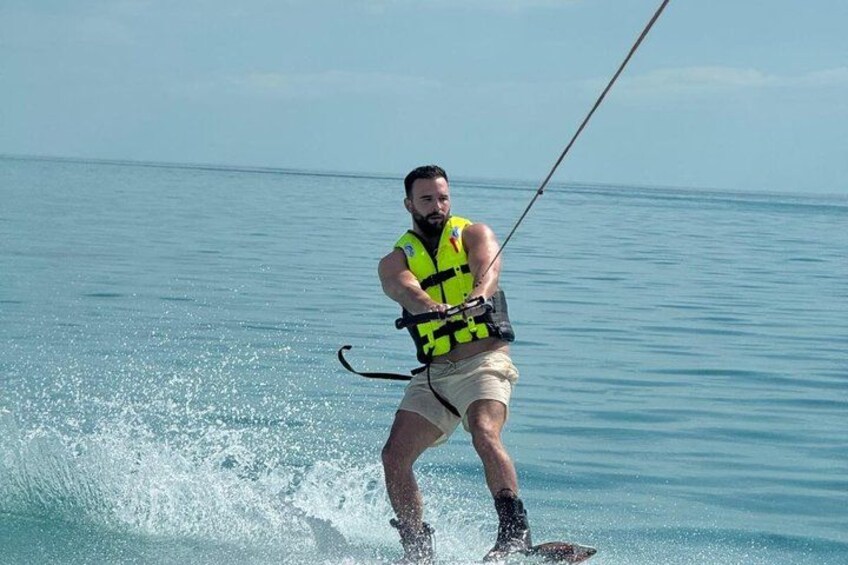 A person water skiing on a calm body of water. 3