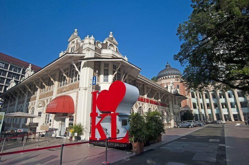 A large red heart sculpture in front of a historic building with columns and a dome. 1