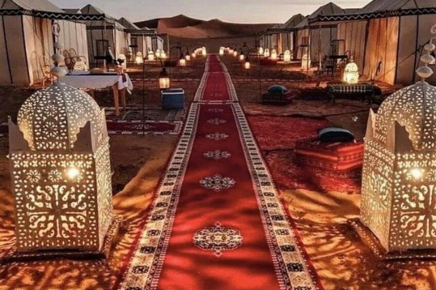 Une caravane avec des tentes, une moquette rouge et des lanternes décorées. 3