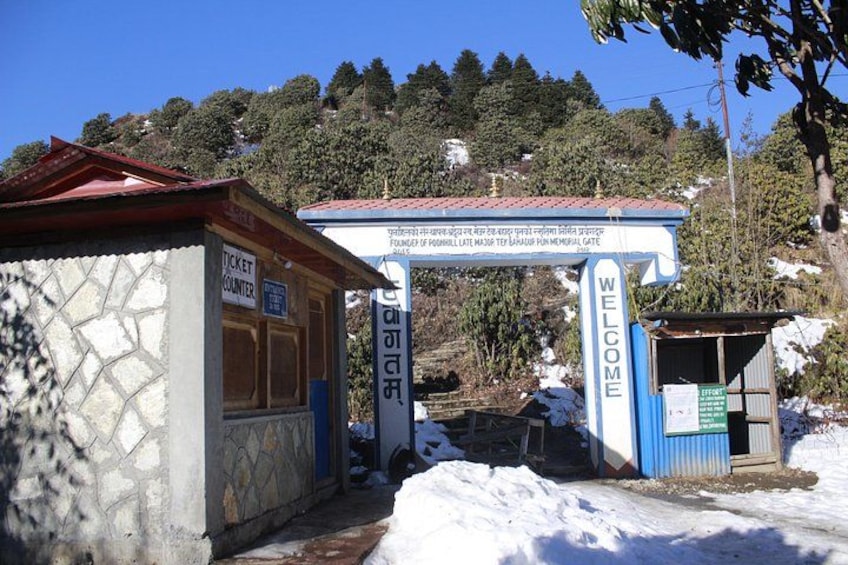 Un mostrador de boletos, un cartel de bienvenida y una puerta conmemorativa en un paisaje nevado. 4