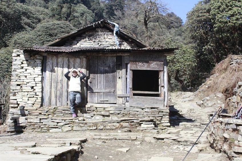 Un edificio rústico de piedra con puerta y ventana de madera, rodeado de un paisaje montañoso. 2