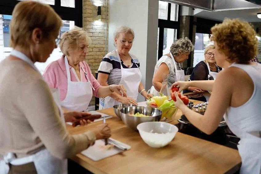 A group of people preparing food in a kitchen. 2